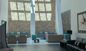 Image of Portuguese hospital waiting room furnished with grey couches with blue cushions, Portuguese healthcare for foreigners | GetNif