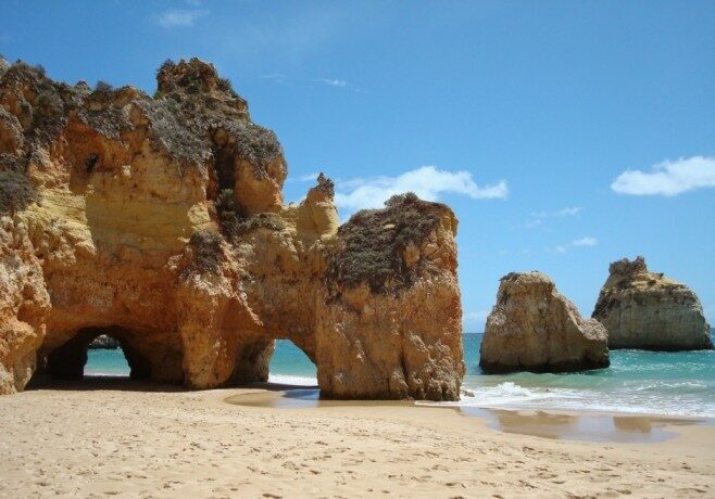 Algarve beach with large rock formations and turquoise waters, benefits of moving to Portuga from USA on the Golden Visa | GetNif