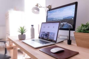 Image of a laptop hooked up to a larger monitor with mouse on a maroon mousepad at front, tips for applying for jobs in Portugal | GetNif