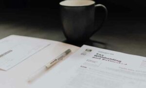 Image of Tax papers and black biro with black mug in background, tax consulting Portugal | GetNif