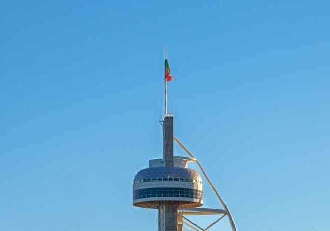 Image of sky tower with a Portugal flag waving on a pole above the tower | Portugal visa | GetNif